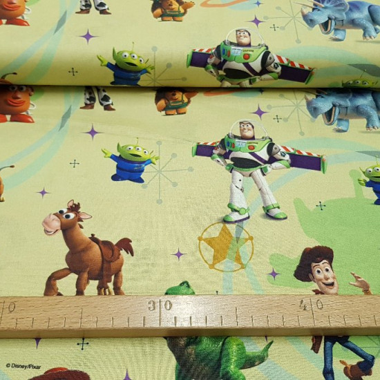 Tela Algodón Disney Toy Story Tela Algodón Disney Toy Story - Tela de algodón infantil Disney de Toy Story. Aparecen los personajes Woody, Buzz, Mr.Potato... sobre un fondo donde predominan los colores amarillo claro y verde. La tela mide 150cm de ancho y su composición 100% al